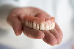 Full Upper Denture on a patient's palm