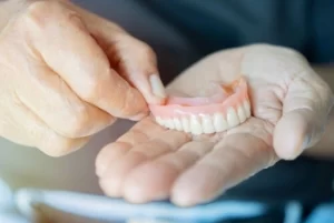 full upper denture on a patient hand